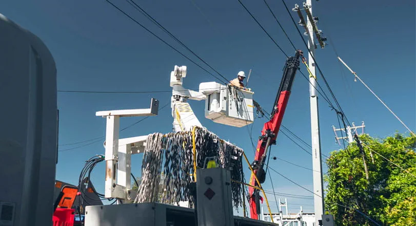 Contractors working in bucket truck up power pole