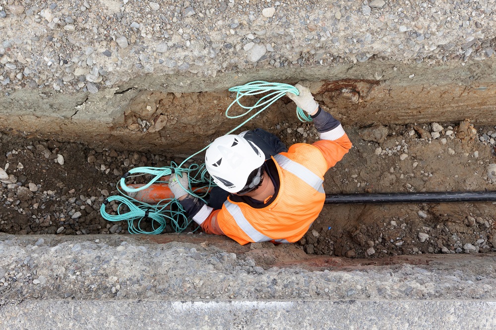 Worker in trench with electricity cable