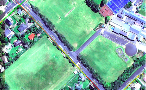 A satellite image showing bird's eye view of green fields, trees and buildings